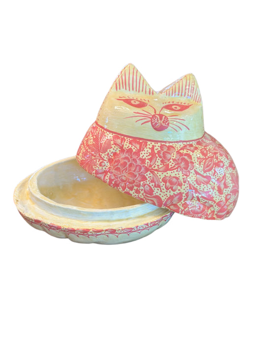 Decorative pink and white cat-shaped box on a wooden surface