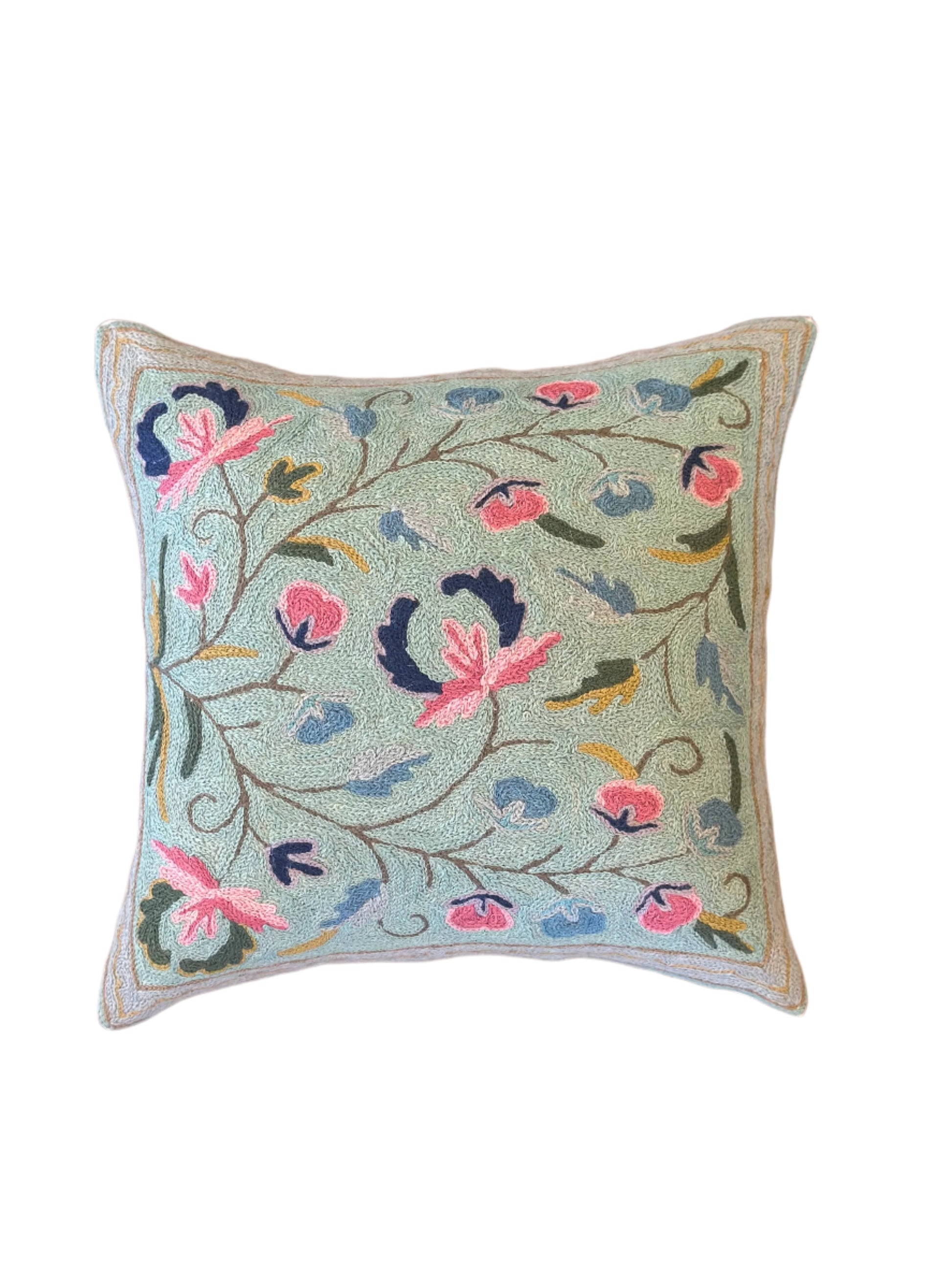 Decorative pillow with floral embroidery on a wooden surface