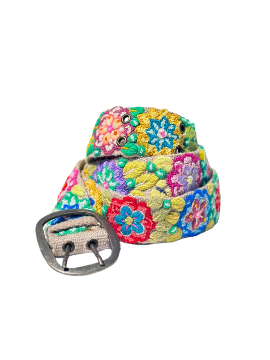 Colorful floral-patterned belt with a silver buckle on a white surface.
